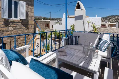 a balcony with a white couch and a table at Finieli's Rustico in Malona Village