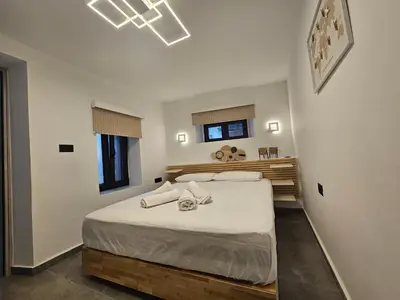 a bedroom with a bed with white sheets and pillows at A&A Niohori Home in Rhodes Town