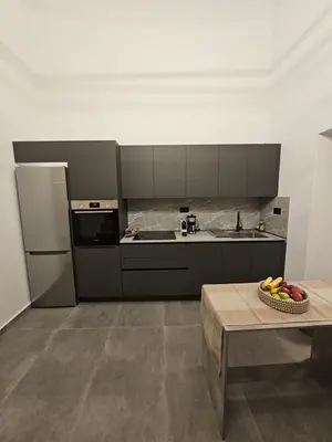 a kitchen with a bowl of fruit on a table at A&A Niohori Home in Rhodes Town