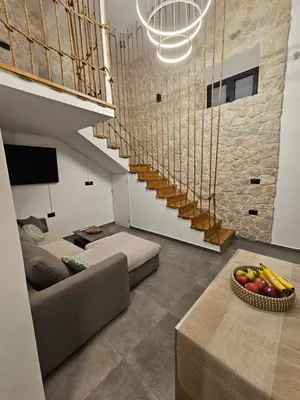 a living room with a couch and a staircase at A&A Niohori Home in Rhodes Town