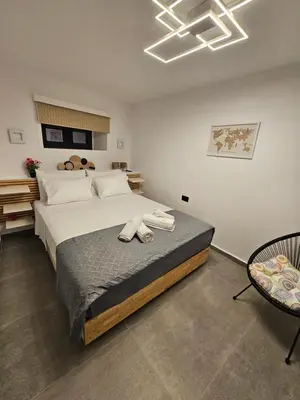 a bedroom with a large bed with two pairs of shoes at A&A Niohori Home in Rhodes Town