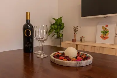 a bottle of wine and a bowl of fruit and a wine glass at Christina's Apartment in Afantou