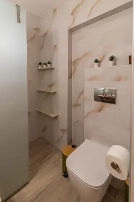 a bathroom with a white toilet and some shelves at Christina's Apartment in Afantou