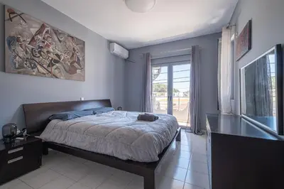 a bedroom with a bed and a large window at Kounaki Wines Central Square Apartments in Émbonas