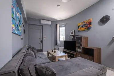 a living room with a couch and a tv at Kounaki Wines Central Square Apartments in Émbonas