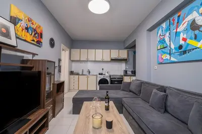 a living room with a couch and a television at Kounaki Wines Central Square Apartments in Émbonas