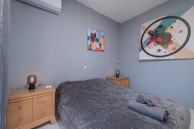 a bedroom with a bed and a painting on the wall at Kounaki Wines Central Square Apartments in Émbonas