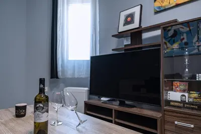 a bottle of wine sitting on a table with two wine glasses at Kounaki Wines Central Square Apartments in Émbonas