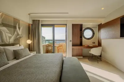 a hotel room with a bed and a view of the ocean at Cento Palme in Rhodes Town