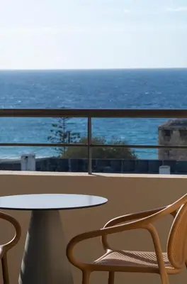 a table and chairs on a balcony with the ocean at Cento Palme in Rhodes Town