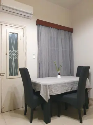 a dining room table and chairs with a white table and a window at Yiannis Sokaki House in Rhodes Town