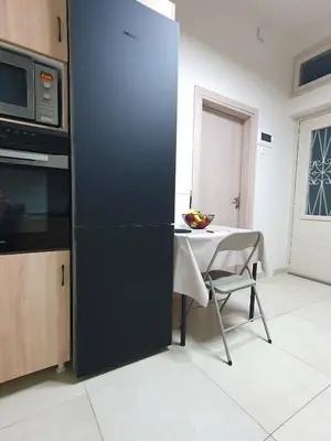 a kitchen with a table and a black refrigerator at Yiannis Sokaki House in Rhodes Town