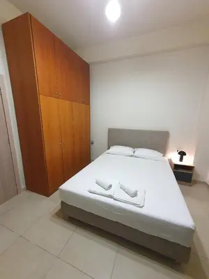 a bedroom with a large white bed with wooden cabinets at Yiannis Sokaki House in Rhodes Town