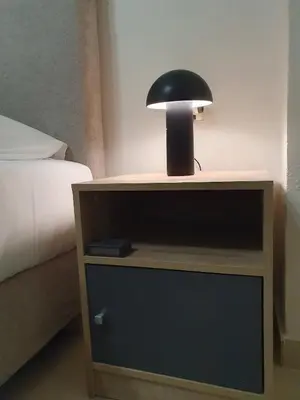 a black lamp on a night stand next to a bed at Yiannis Sokaki House in Rhodes Town