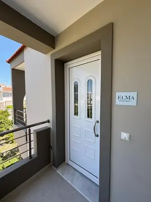 a white door in a house with a balcony at ELMA apartment 1 Kremasti in Kremasti