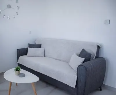 a gray couch in a living room with a table at ELMA apartment 1 Kremasti in Kremasti