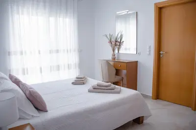 a bedroom with a white bed with towels on it at ELMA apartment 1 Kremasti in Kremasti