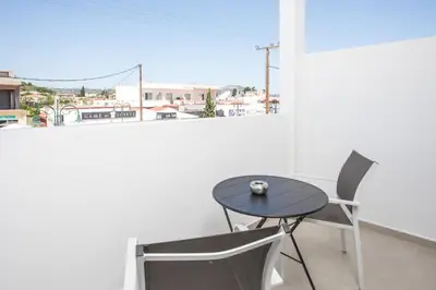 a small table and chair in a room with a window at Pado Living in Faliraki