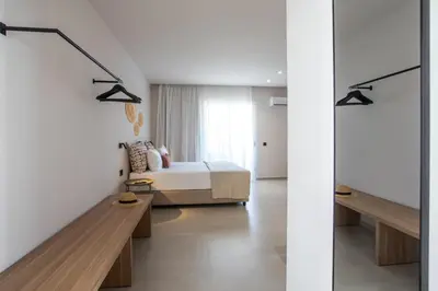 a bedroom with a bed and a glass wall at Pado Living in Faliraki