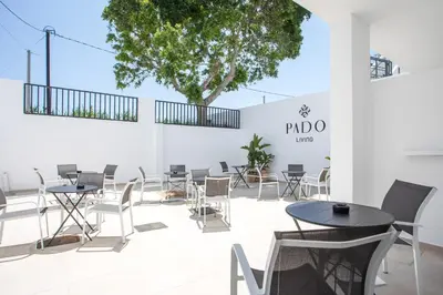 a room with tables and chairs and a tree at Pado Living in Faliraki