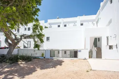 a white building with a tree in front of it at Pado Living in Faliraki