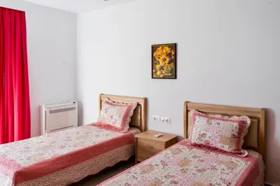 two beds in a room with red curtains at Estrella Villas in Lardos