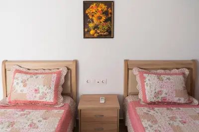 a bedroom with two beds and a picture on the wall at Estrella Villas in Lardos