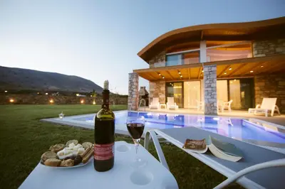 a bottle of wine sitting on a table with a glass of wine at Estrella Villas in Lardos