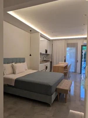 a bedroom with a bed and a kitchen and a table at Nirea Studio II in Faliraki