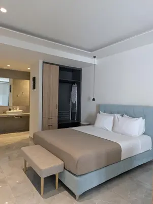 a bedroom with a large bed and a bathroom at Nirea Studio II in Faliraki