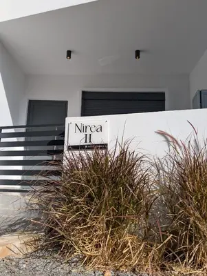 a sign in front of a building with some plants at Nirea Studio II in Faliraki