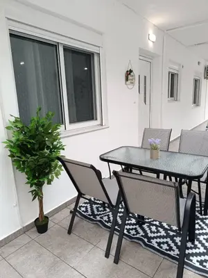 a patio with a table and chairs and a potted plant at Tatti's Apartment in Rhodes Town