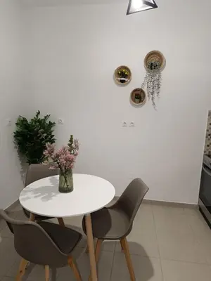 a white table with chairs and a vase of flowers at Tatti's Apartment in Rhodes Town