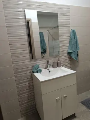 a bathroom with a white sink and a mirror at Tatti's Apartment in Rhodes Town