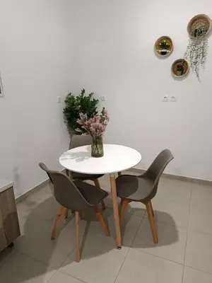 a white table with two chairs and a vase with flowers at Tatti's Apartment in Rhodes Town