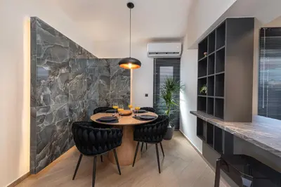 a dining room with a table and black chairs at Dolce Casa Suite2 in Afantou