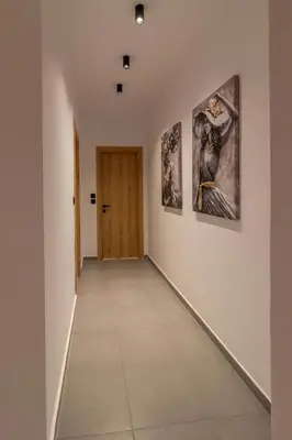 a hallway with three paintings on the wall at Antonis Traditional House in Afantou