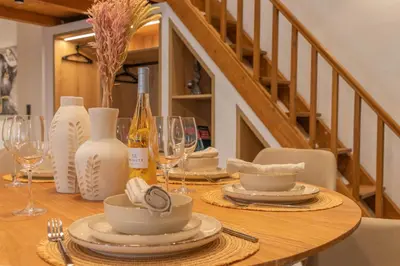 a wooden table with plates and wine glasses on it at Antonis Traditional House in Afantou