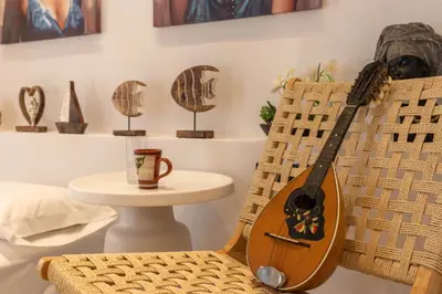 a guitar sitting on a chair next to a table at Antonis Traditional House in Afantou