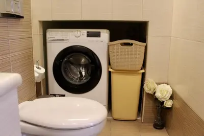 a bathroom with a washing machine and a toilet at Villa Moné in Koskinou