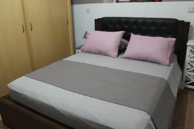 a bed with two pink pillows on top of it at Villa Moné in Koskinou
