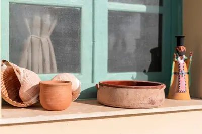 a shelf with bowls and vases on a window at Villa Panagiota, Pefkos in Pefki Rhodes