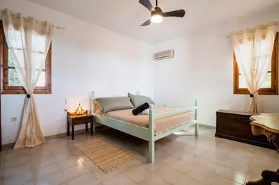 a bedroom with a bed and a ceiling fan at Villa Panagiota, Pefkos in Pefki Rhodes