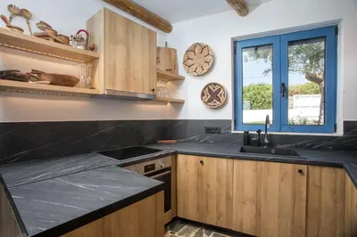 a kitchen with wooden cabinets and a sink and a window at Villa Mare Mio, beachfront, newly rennovated in Lachania
