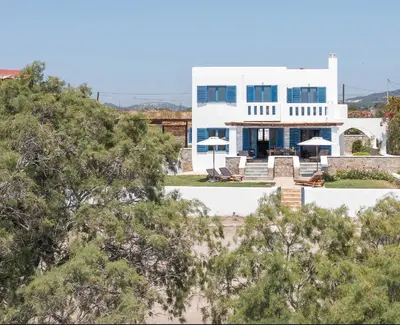 a large white house with trees in front of it at Villa Mare Mio, beachfront, newly rennovated in Lachania