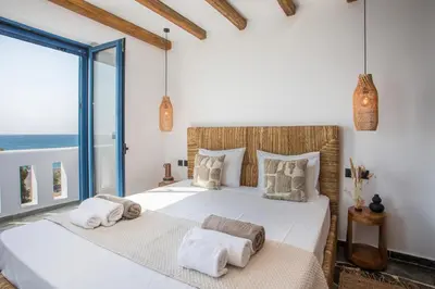 two beds in a bedroom with a view of the ocean at Villa Mare Mio, beachfront, newly rennovated in Lachania