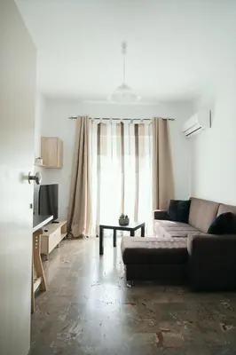 a living room with a couch and a window at ANASTASIAS HOUSE a in Rhodes Town