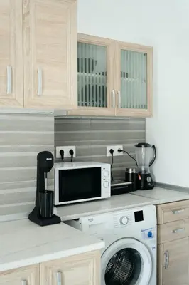 a kitchen with a washing machine and a microwave at ANASTASIAS HOUSE a in Rhodes Town