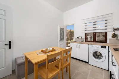 a kitchen with a table and a washing machine at Elpidas Apartments in Symi