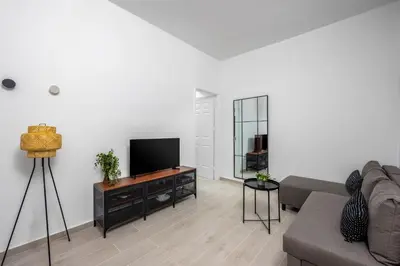 a living room with a couch and a flat screen tv at Elpidas Apartments in Symi